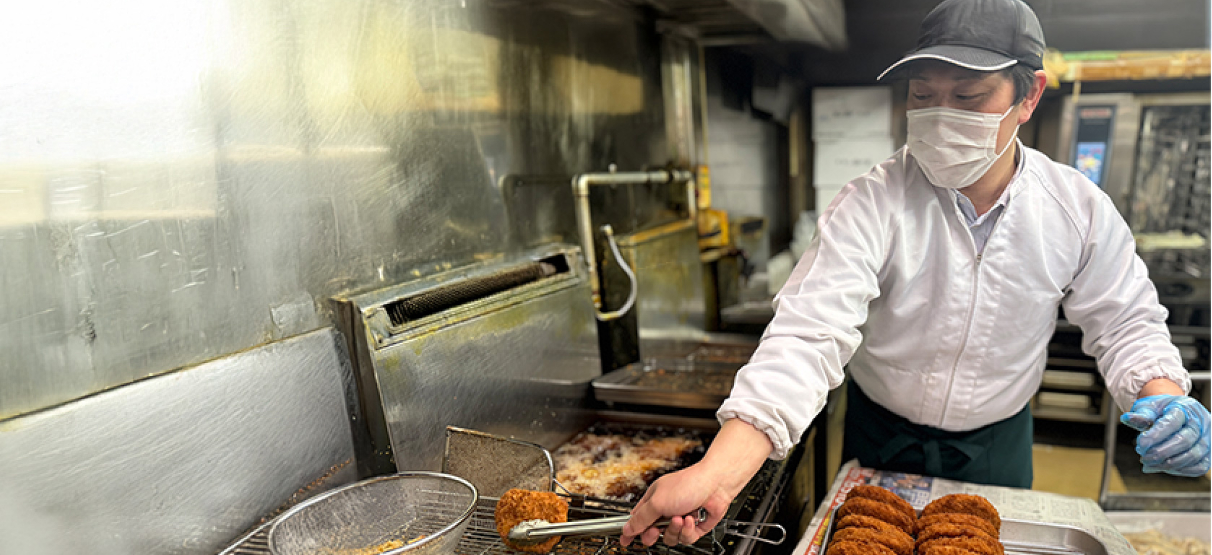 キャベツ畑で野菜を手に持つ生産者